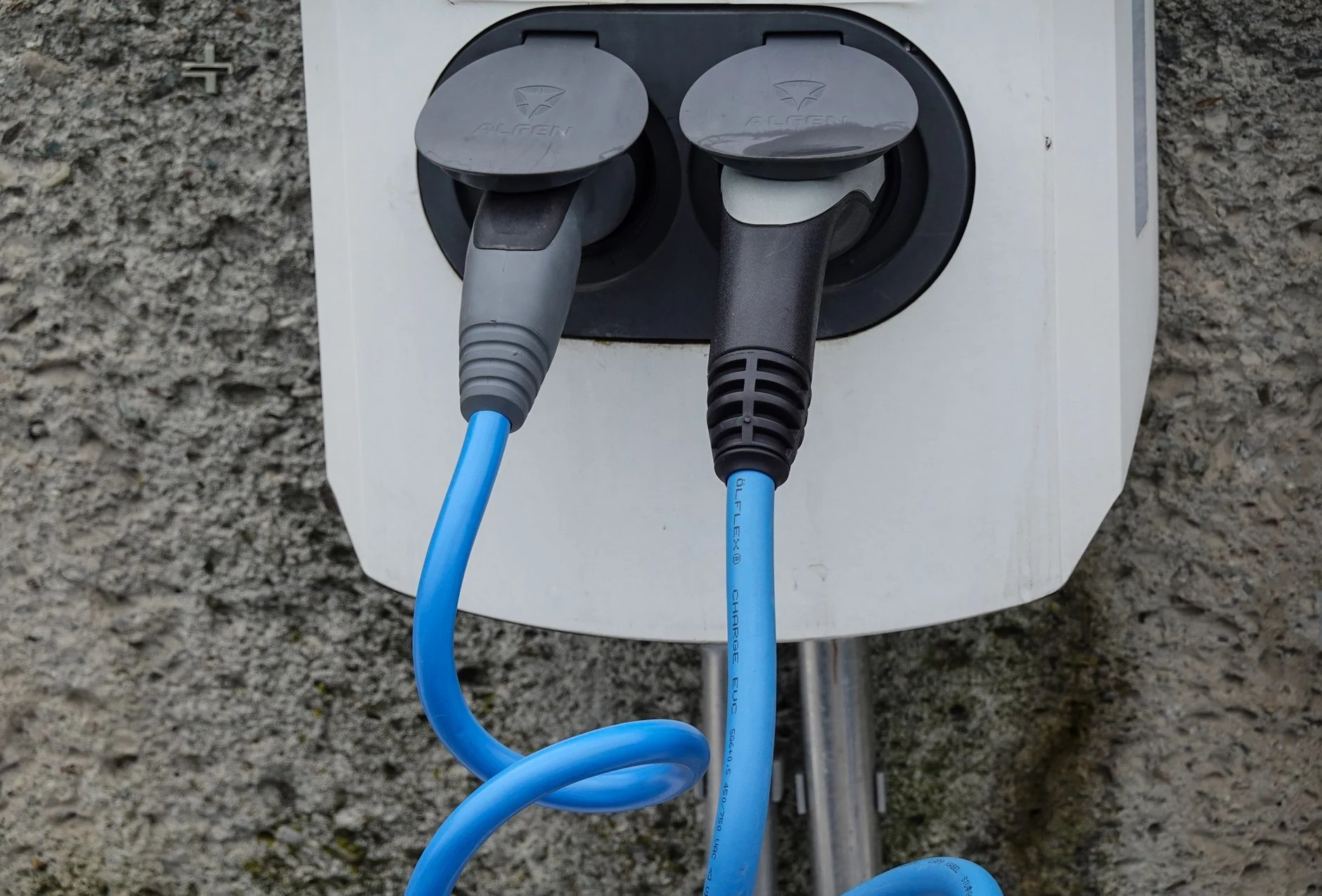 Commercial electric bus fleet beside modern EV charging station.